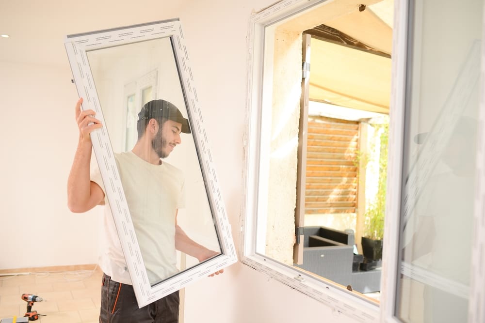 Worker carefully fitting a new window frame into place during a home renovation project – Window Installation Springfield MO